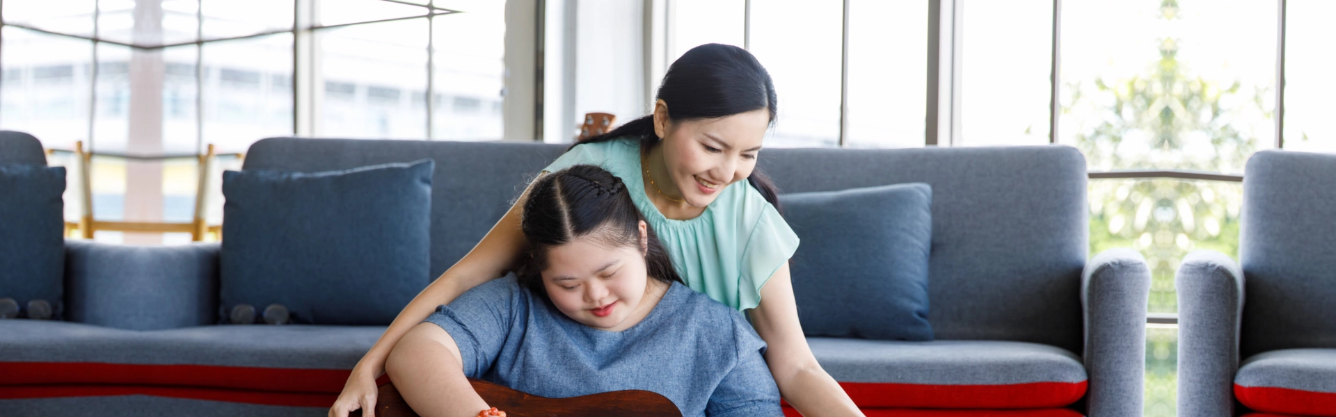 woman teaching the kid how to guitar